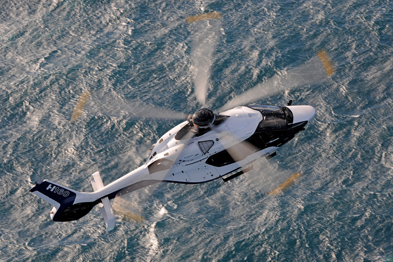 H160 flying over ocean
